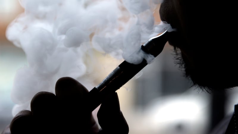 FILE - In this April 23, 2014 file photo, a man smokes an electronic cigarette in Chicago....